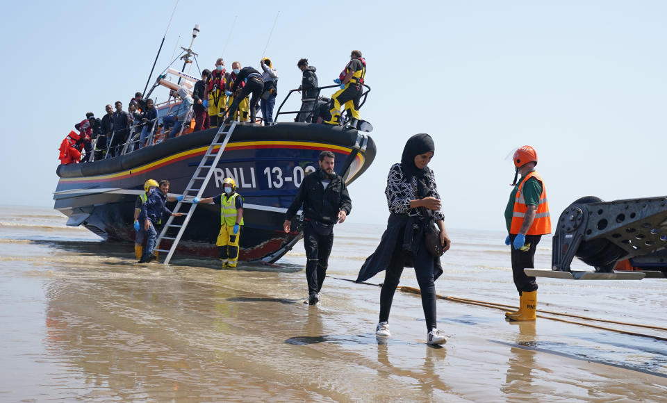 <p>A group of people thought to be migrants crossing from France come ashore from the local lifeboat at Dungeness in Kent, after being picked-up following a small boat incident in the Channel. Picture date: Tuesday July 20, 2021.</p>
