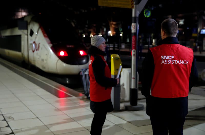 Trabajadores ferroviarios franceses de la SNCF se paran en una plataforma para prestar asistencia a los pasajeros del ferrocarril de Lille durante una jornada de huelga nacional y protestas contra los planes de reforma de las pensiones del gobierno francés