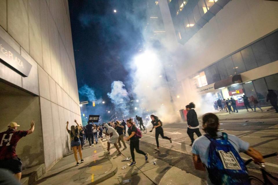 Protesters scramble on Fourth Street as police fire tear gas from both sides of the block in uptown Charlotte on June 2, 2020. Joshua Komer/The Charlotte Observer