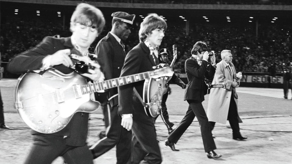 Harrison, Lennon (left) and McCartney (right) walk to the stage at Candlestick Park for the  last show of their final tour, August 29, 1966.