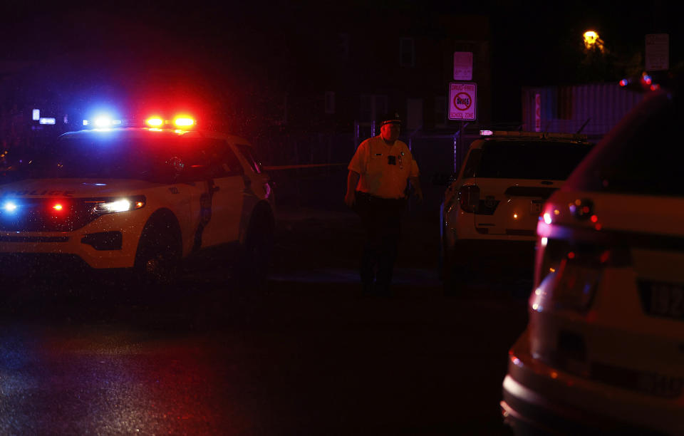 A Philadelphia police officer stands guard at the intersection of 56th Street and Kingsessing Avenue after multiple people were shot in Southwest Philadelphia, late Monday, July 3, 2023. (Yong Kim/The Philadelphia Inquirer via AP)