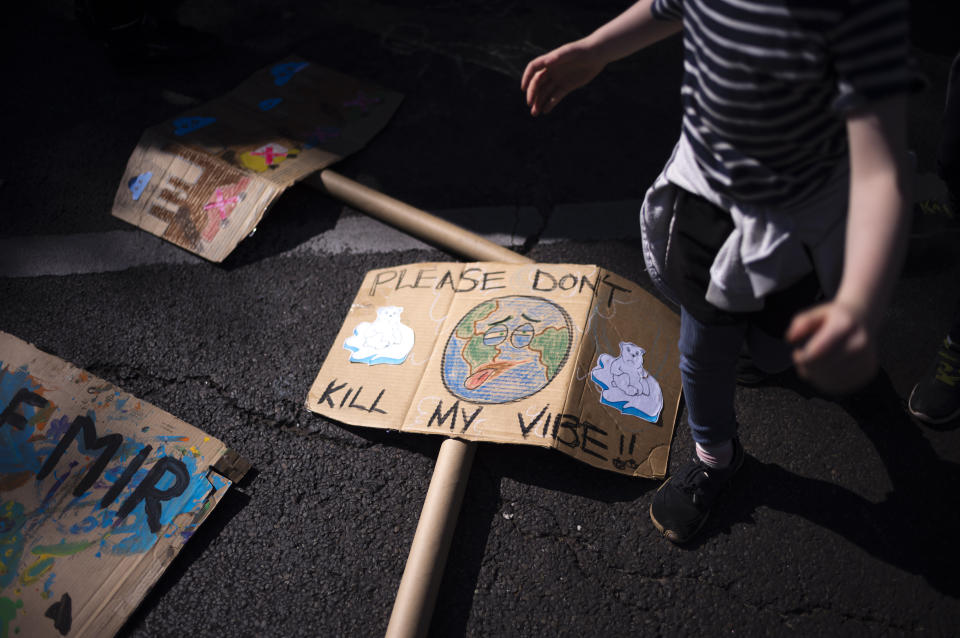 A child walks near a poster on the ground during a Global Climate Strike 'Fridays For Future' protest in Berlin, Germany, Friday, Sept. 15, 2023. Tens of thousands of climate activists around the world are set to march, chant and protest Friday to call for an end to the burning of planet-warming fossil fuels as the globe continues to suffer dramatic weather extremes and topple heat records. (AP Photo/Markus Schreiber)