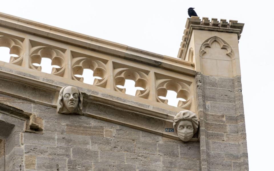 Carved stone sculpture in Christchurch Priory showing a National Health Service worker wearing a face mask during the Covid-19 pandemic - Gillian Pullinger/Alamy 