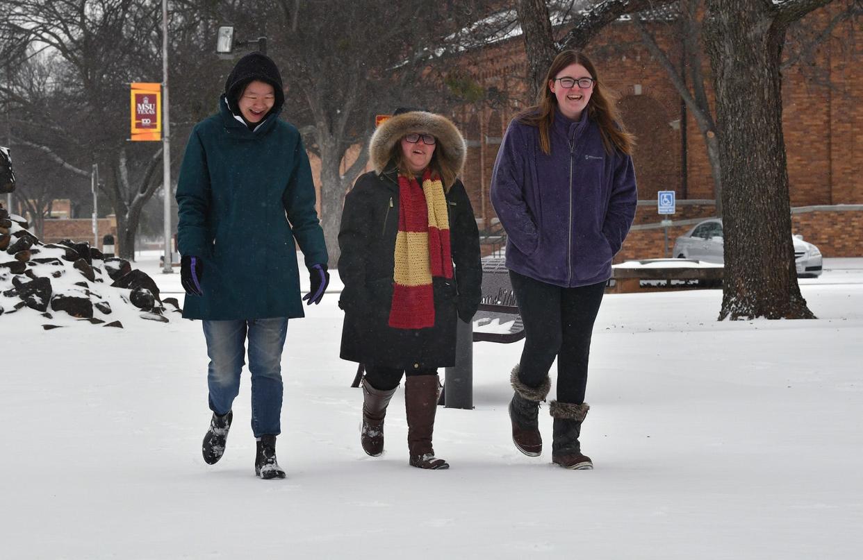 Midwestern State University students Anna Corry, left, Ashli Gafford and Maddie Paulson, right, walked around campus Thursday morning to check out the fresh snow.
