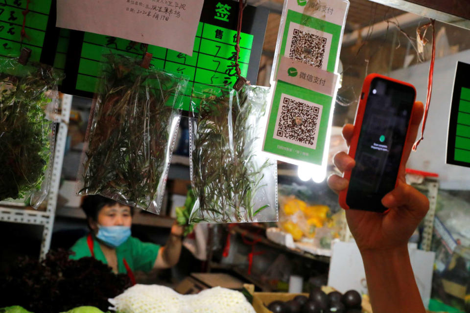 A person scans the QR code of the digital payment services WeChat Pay at a fresh market in Beijing, China.