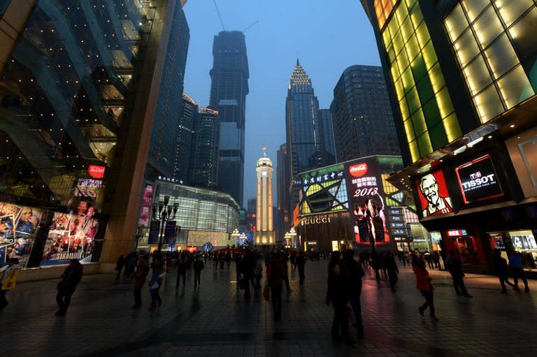 Shoppers walk around the Liberation Monument in Chongqing, February 2, 2013. Following the downfall of Bo Xilai, changes in the 33-million-strong municipality, such as legal attempts to overturn what human rights lawyers see as unjust verdicts during Bo's tenure, have foundered