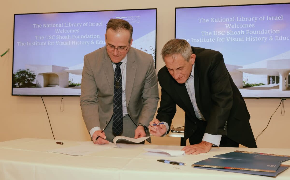 Shoah Foundation Executive Director Robert Williams and National Library of Israel Chairman Sallai Meridor sign a memorandum of understanding at the library in Jerusalem on Mar. 4, 2024.