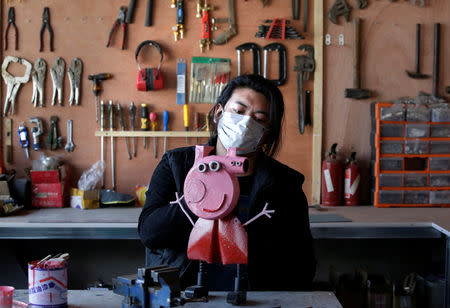 Geng Shuai, dubbed "Useless Edison" by his fans, works on a sculpture depicting animated series character Peppa Pig, made of an air blower, at his workshop in Yangcun village of Baoding, Hebei province, China January 22, 2019. REUTERS/Jason Lee