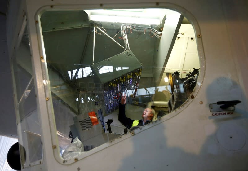 Test pilot David Burns sits in the cockpit of the Airlander 10 hybrid airship during its unveiling in Cardington, Britain March 21, 2016. It will undertake additional ground testing before a first flight in the coming months. The airship could then become a familiar sight over the central English countryside as it aims to complete 200 hours of test flights before demonstrations to would-be customers. REUTERS/Darren Staples