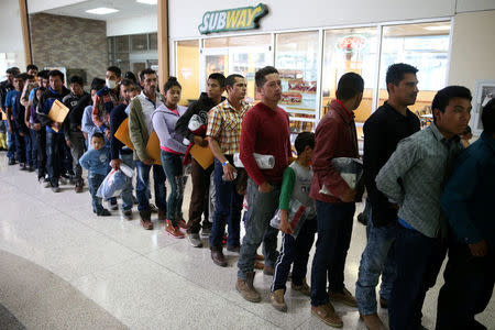 FILE PHOTO: Undocumented immigrants just released from detention through "catch and release" immigration policy stand at a bus station before being taken to the Catholic Charities relief center in McAllen, Texas, U.S., April 11, 2018. REUTERS/Loren Elliott/File Photo