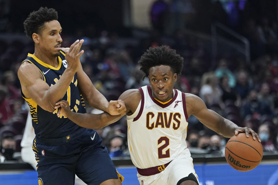 Cleveland Cavaliers' Collin Sexton (2) drives past Indiana Pacers' Malcolm Brogdon (7) in the first half of an NBA basketball preseason game, Friday, Oct. 8, 2021, in Cleveland. (AP Photo/Tony Dejak)