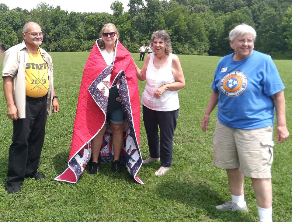 Carlos Reyes and Marsha Reep of the Local Quilt of Valor group present a quilt to Christine Page, USNR veteran. With them is Marilyn Childress, president of the Knoxville chapter of the Veterans Heritage Site Foundation.