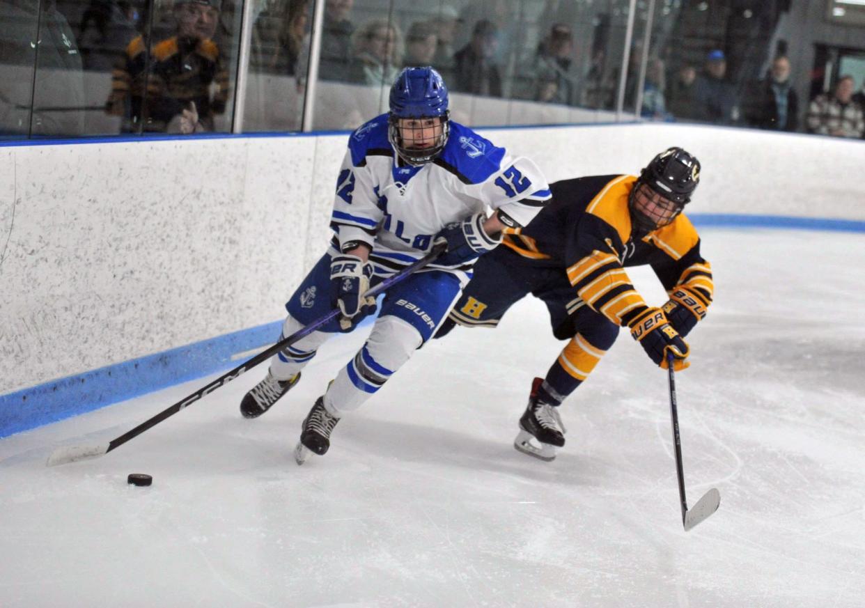 Scituate's Alex Devereaux, left, is defended by Hanover's Sean Larvey during boys high school hockey action at the Hobomock Arena in Pembroke, Wednesday, Feb. 7, 2024.