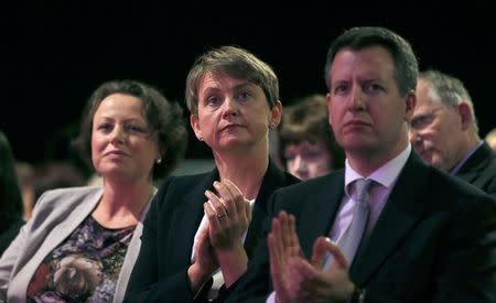 Britain's shadow home secretary Yvette Cooper (C), listens to her husband, shadow chancellor Ed Balls, speak at the Labour Party's annual conference in Manchester, northern England September 22, 2014. REUTERS/Suzanne Plunkett