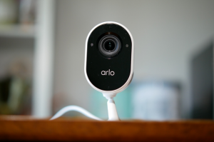 white arlo indoor camera sitting on shelf