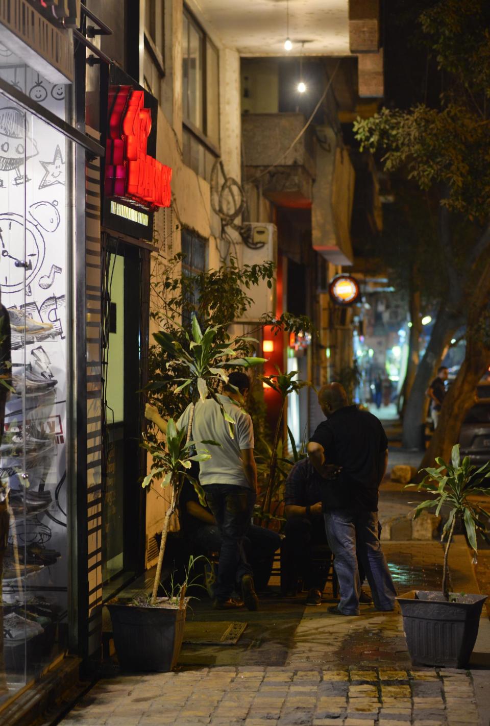 Egyptians chat is a shopping street in Cairo, Egypt, Wednesday, Oct. 31, 2012. Egypt’s capital prides itself on being city that never sleeps, with crowds filling cafes and shops open into the small hours. So the government is facing a backlash from businesses and the public as it vows to impose new nationwide rules closing stores and restaurants early. Officials say the crisis-ridden nation has to conserve electricity, but they also seem intent on taming a population they see as too unruly. (AP Photo)