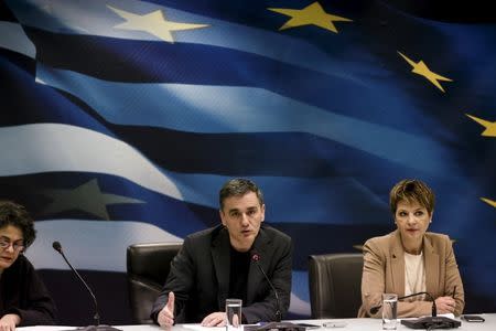 Greek Finance Minister Euclid Tsakalotos (C) addresses journalists as government spokeswoman Olga Gerovasili (R) looks on during a news conference at the ministry in Athens, Greece, January 18, 2016. REUTERS/Alkis Konstantinidis