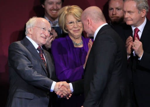 Newly elected Irish President Michael D Higgins (L) shales hands with his former rival Sean Gallagher (C) as Sinn Fein party's Martin McGuinness (R) looks on during the official announcement of the Irish presidential election's results at Dublin Castle in Dublin