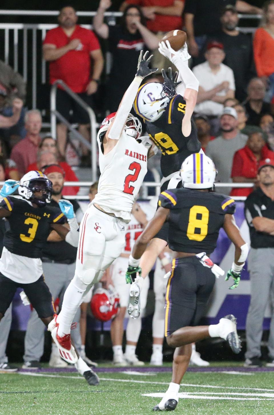 Calvary's Sam Anderson hauls in an interception intended for Savannah Christian's Logan Brooking during Friday night's game at Calvary.