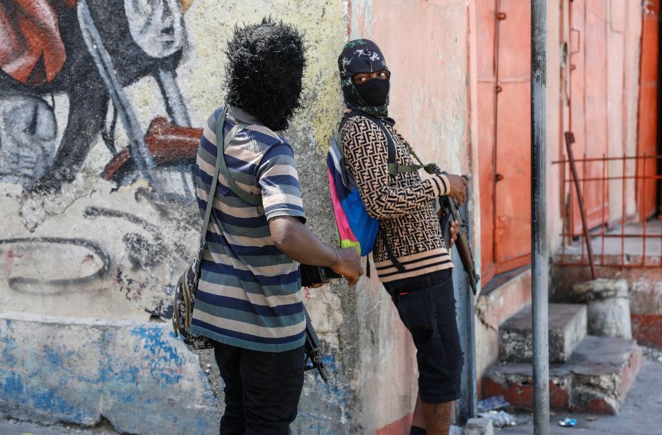 Members of the G9 and Family gang speak to each other while standing guard at their roadblock in the Delmas 6 neighborhood of Port-au-Prince, Haiti, Monday, March 11, 2024. (AP Photo/Odelyn Joseph)