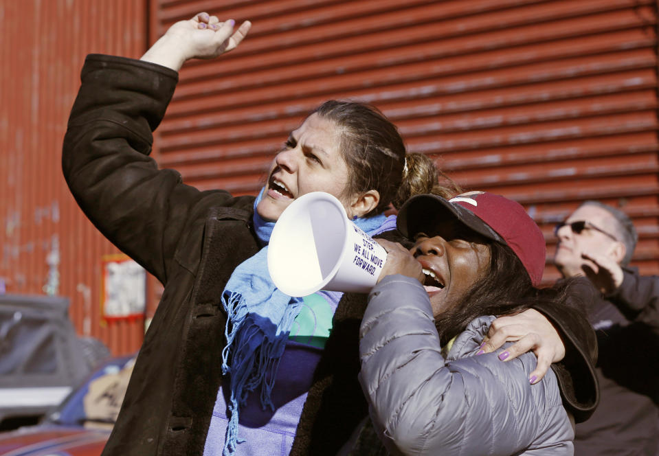 Veronica Matus, 42, an activist from Queens, left, embraces Catana Yehudah, 50, of the Bronx, as Yehuda speaks into the microphone Sunday, Feb. 3, 2019, in New York, at prisoners listening from inside their cells at the Metropolitan Detention Center, a federal facility of all security levels, where prisoners have been without heat, hot water, electricity and proper sanitation due to an electrical failure since earlier in the week. Yehuda's brother Jason Smith, 40, is serving an 18-month sentence in the prison for gun possession. (AP Photo/Kathy Willens)