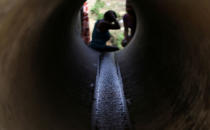 <p>Emilia Santos washes her hair with mountain spring water coming through a pipe, after the island was hit by Hurricane Maria in September, in Toa Alta, Puerto Rico, Oct. 19, 2017. (Photo: Alvin Baez/Reuters) </p>