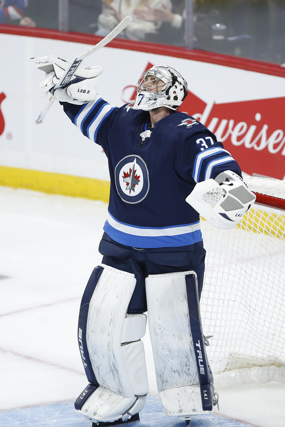 Winnipeg Jets goaltender Connor Hellebuyck (37) celebrates the team's win over the New Jersey Devils in an NHL hockey game Friday, Dec. 3, 2021, in Winnipeg, Manitoba. (John Woods/The Canadian Press via AP)