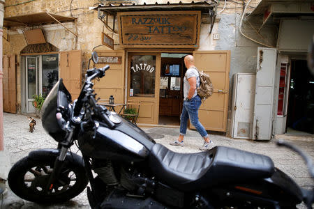 A man walks past the studio of tattoo artist, Wassim Razzouk, who is continuing his family's tradition of inking Christian pilgrims with ancient tattoos, in Jerusalem's Old City November 27, 2017. Picture taken November 27, 2017. REUTERS/Amir Cohen