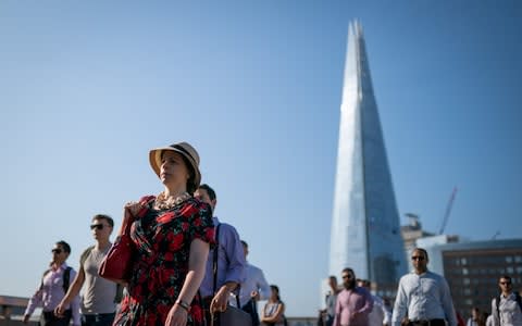 Commuters cross London Bridge as temperatures soar - Credit: SWNS