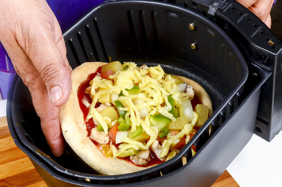 A pizza being cooked in an air fryer