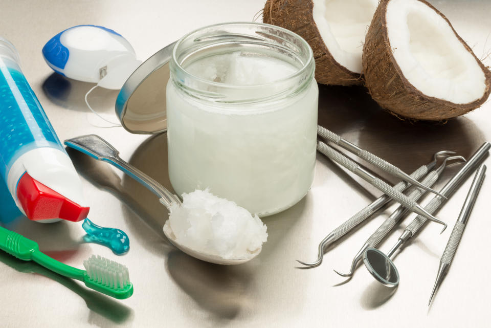 Selection of dentists tools. Oil pulling is one of the most popular dental trends on TikTok -- but does it work? Yahoo Canada spoke to an expert to find out. (Getty Images) on a stainless steel background with coconut oil, toothpaste, toothbrush and floss. Heaped dessert with cocunut oil by jar.