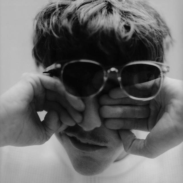 Single cover for "A Little More Time" by Role Model, showing Role Model rubbing his eyes behind sunglasses