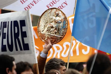 A notary sign is held high during a national protest by French lawyers, notaries and bailiffs against a government reform plan to deregulate their profession in Paris December 10, 2014. REUTERS/Charles Platiau