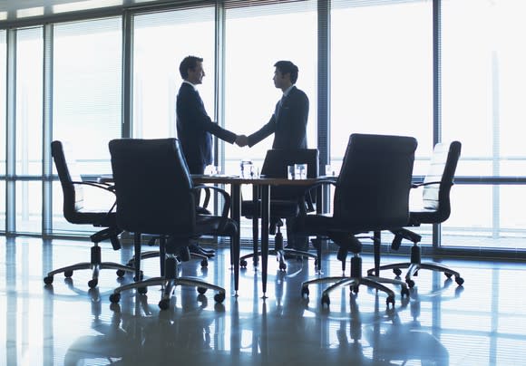 Two men shaking hands in a conference room