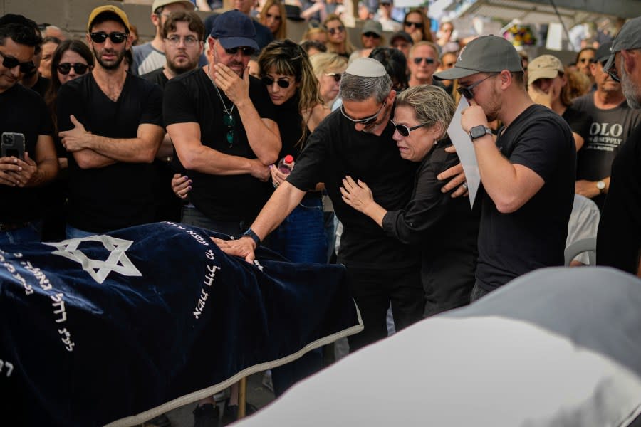 Mourners gather in grief around the bodies of Danielle Waldmann and her partner Noam Shai during their funeral in the northern Israeli town of Kiryat Tivon Thursday, Oct. 12, 2023. (AP Photo/Ariel Schalit)