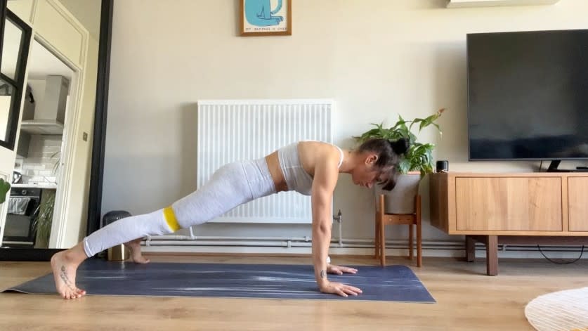 Writer Sam performing plank jacks banded at home on exercise mat