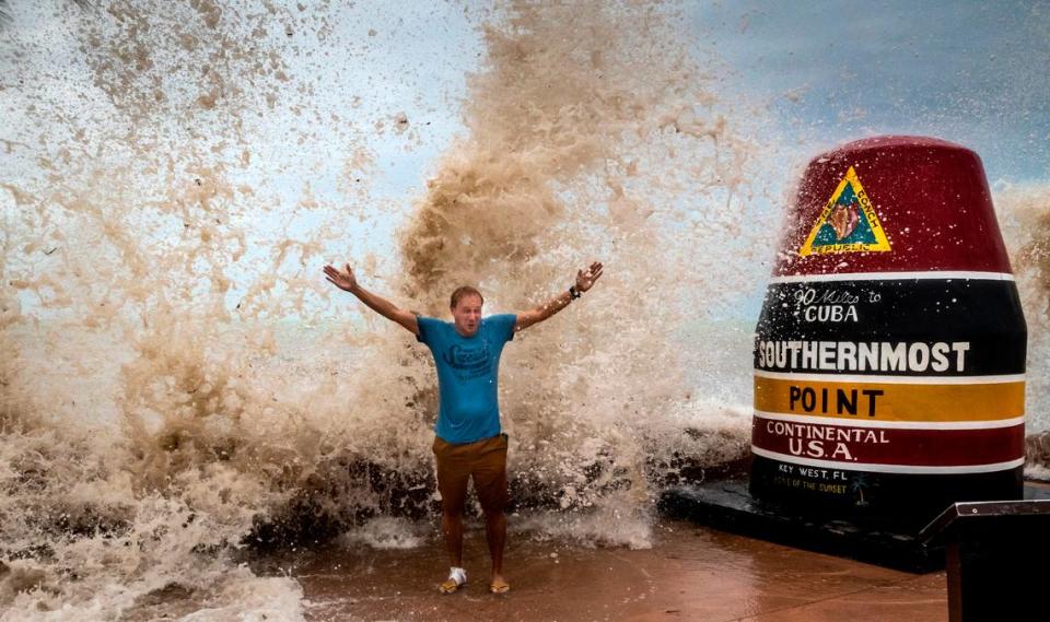 Sander Eshuis, a tourist from Holland, poses for a photo as he is doused by waves at the Southernmost Point marker in Key West, Florida, on Sept. 27, 2022. Sander and his wife, Lenneke, had never experienced a hurricane before and the proximity of Hurricane Ian to Key West allowed them to see some of the effects of the storm from a distance.