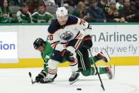 Edmonton Oilers center Colton Sceviour (70) takes control of the puck in front of Dallas Stars' Jamie Benn, rear, in the second period of an NHL hockey game in Dallas, Tuesday, Nov. 23, 2021. (AP Photo/Tony Gutierrez)