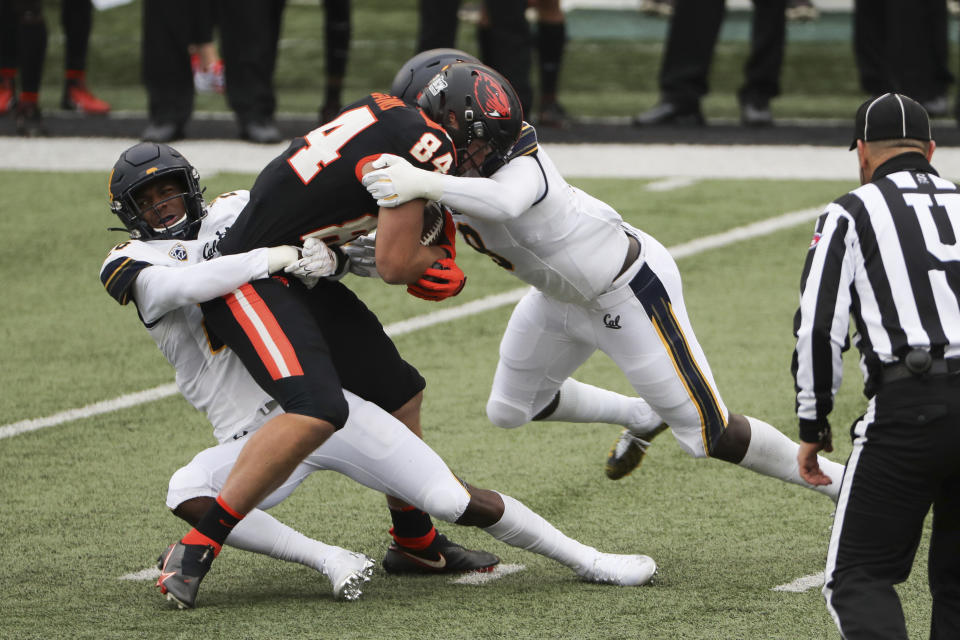 Oregon State tight end Teagan Quitoriano (84) is brought down by California safety Craig Woodson (26) and inside linebacker Kuony Deng (8) during the first half of an NCAA college football game in Corvallis, Ore., Saturday, Nov. 21, 2020. (AP Photo/Amanda Loman)