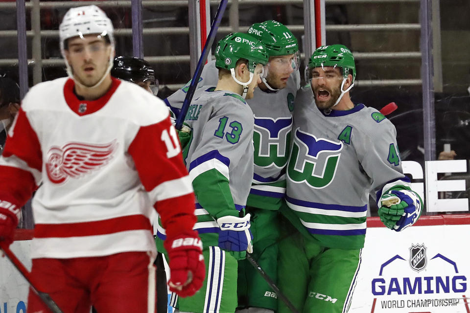 Carolina Hurricanes' Jordan Staal (11), center, is congratulated on his goal by teammates Warren Foegele (13) and Jordan Martinook (48) during the first period of an NHL hockey game against the Detroit Red Wings in Raleigh, N.C., Saturday, April 10, 2021. (AP Photo/Karl B DeBlaker)