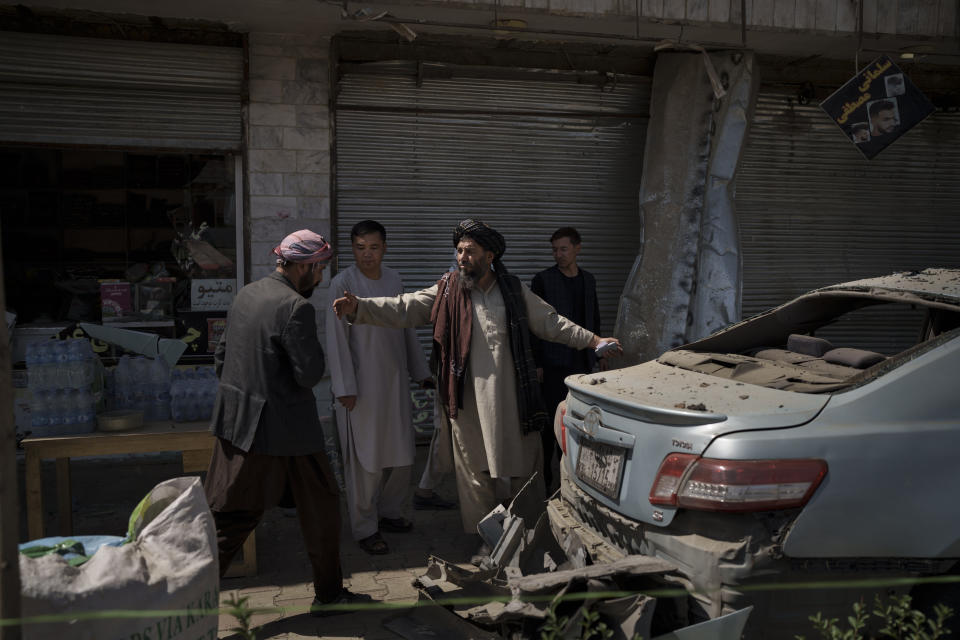 Taliban fighters and residents gather at the site of an explosion in Kabul, Afghanistan, Saturday, Sept. 18, 2021. A sticky bomb exploded in the capital Kabul wounding a few people, said police officials. (AP Photo/Felipe Dana)