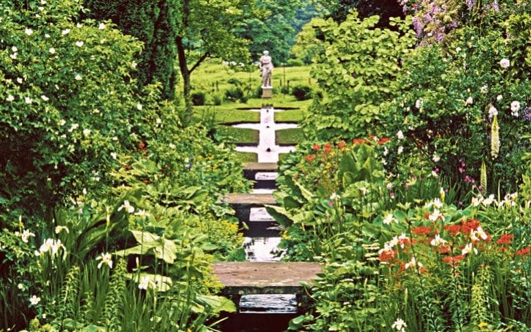 The water rill with stone bridges over at Shute House, UK - GAP PHOTOS