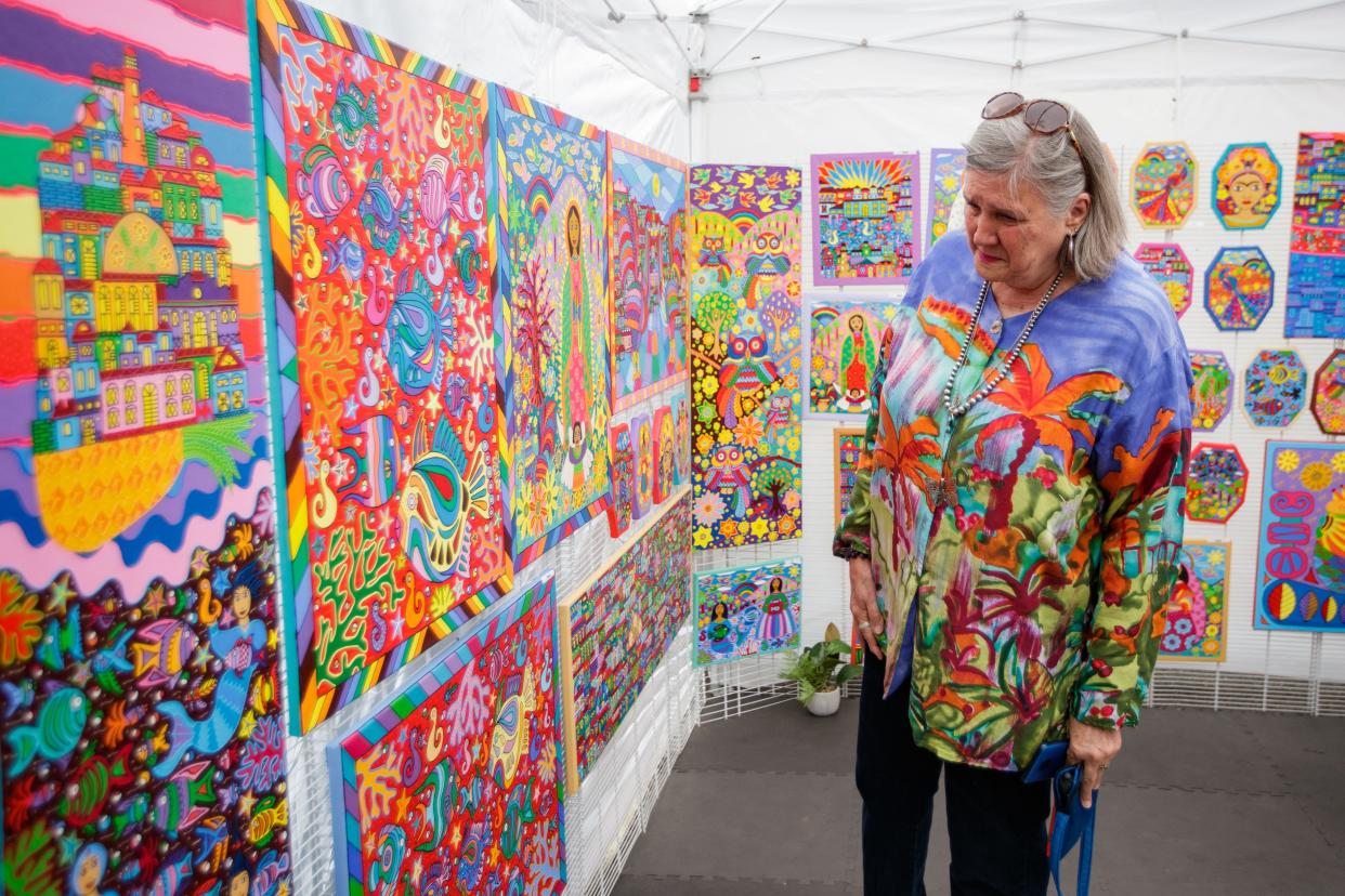 Art lovers enjoy a morning outdoors of shopping as they make their way from one artist's booth to the next during the 22nd LeMoyne Chain of Parks Annual Art Festival on Saturday, April 23, 2022.