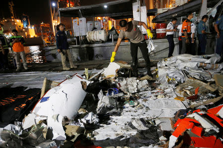 An Indonesian policeman holds wreckage recovered from Lion Air flight JT610 which crashed into the sea, at Tanjung Priok port in Jakarta, Indonesia. REUTERS/Willy Kurniawan