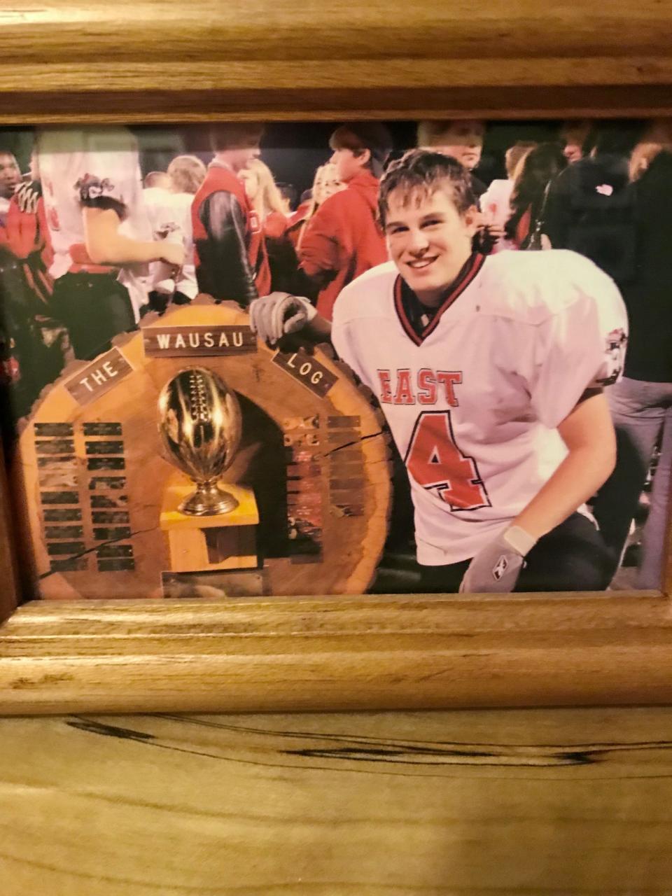 Football was at the center of Ross Jirgl's dreams when he was student at Wausau East High School. He poses here with the Wausau Log, the trophy that goes to the winner of the game between inter-city rival Wausau West High School.