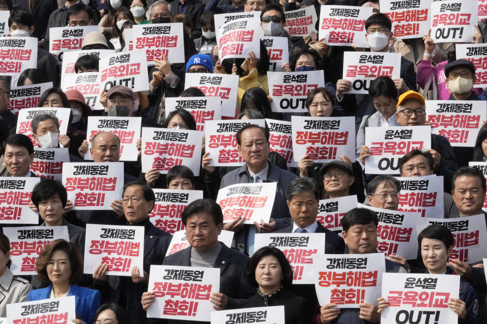 South Korean opposition lawmakers and civic groups stage a rally against the South Korean government's plan over the issue of compensation for forced labors at the National Assembly in Seoul, South Korea, Tuesday, March 7, 2023. South Korean President Yoon Suk Yeol on Tuesday defended his government's contentious plan to use local funds to compensate Koreans enslaved by Japanese companies before the end of World War II, saying it's crucial for Seoul to build future-oriented ties with its former colonial overlord. The signs read "Withdraw, the government's announcement of a plan over the issue of compensation for forced labors." (AP Photo/Ahn Young-joon)