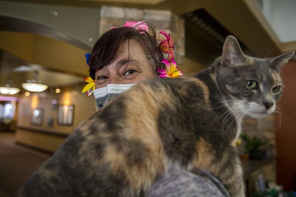 A female cat named Rodger rides on Kimberly Peterson's shoulder at the Inn Between.