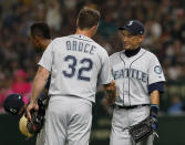 Seattle Mariners right fielder Ichiro Suzuki shakes hands with first baseman Jay Bruce (32) while leaving the field for defense substitution in the fourth inning of Game 1 of a Major League opening baseball series against the Oakland Athletics at Tokyo Dome in Tokyo, Wednesday, March 20, 2019.(AP Photo/Toru Takahashi)