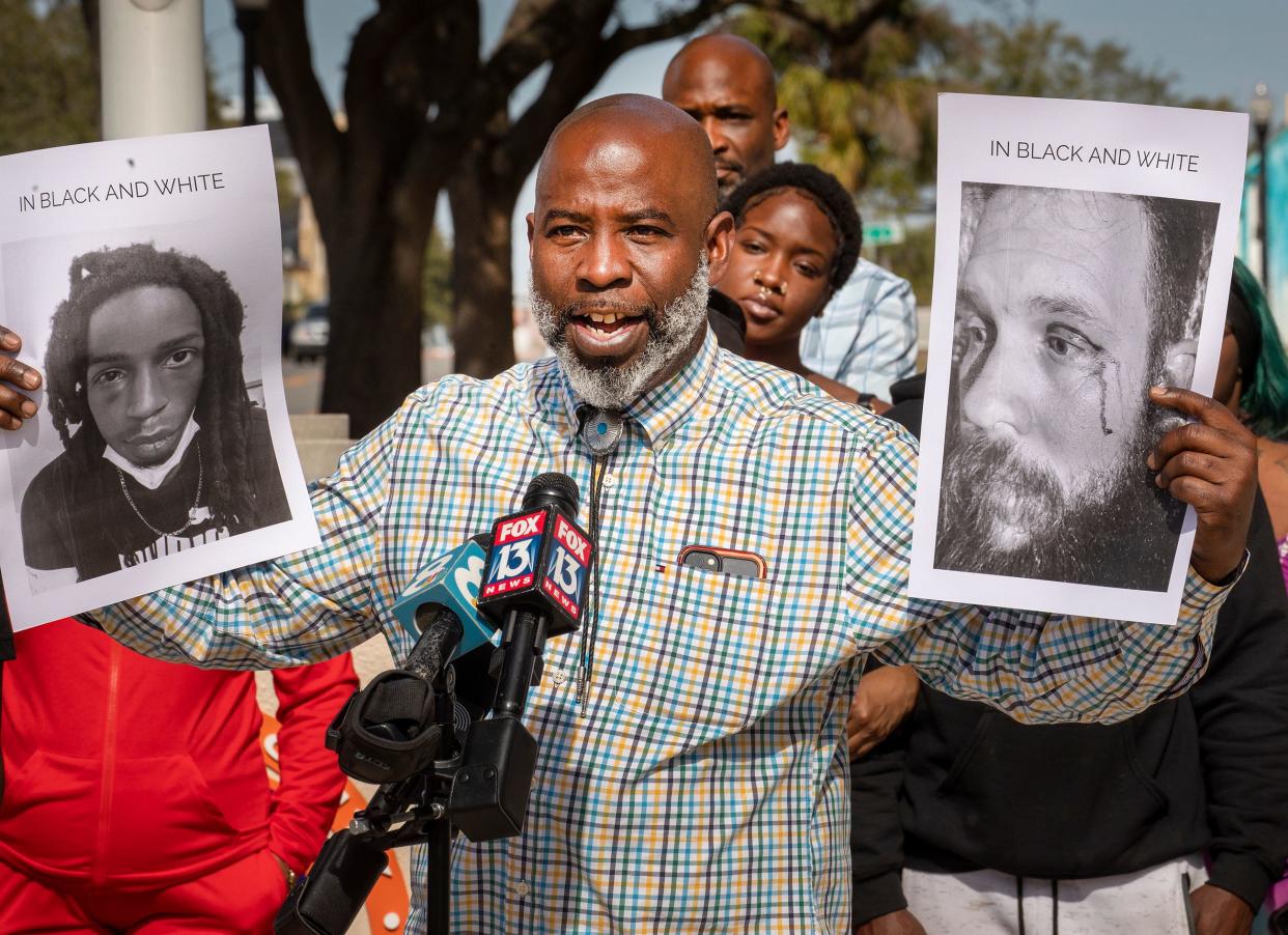 The Rev. Clayton Cowart holds posters of two people he said were beaten by Lakeland police, Timothy Davis, left, and Eric Kent, right, during a Black Lives Matters Restoration Polk Inc. news conference in front of the Lakeland Police Department on Thursday.