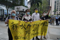 Various defendants including pro-democracy activists Figo Chan Ho-wun, second from left, and Avery Ng, second from right, hold a banner outside a court in Hong Kong, Monday, May 17, 2021. Trial starts for Jimmy Lai and nine others, accused of "incitement to knowingly take part in an unauthorized assembly" for a protest march on Oct. 1, 2019. The court has estimated 10 days for this trial. (AP Photo/Kin Cheung)